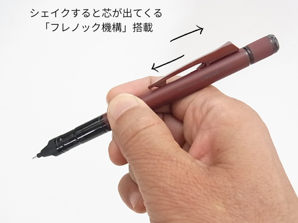 ペンを振って芯を出している手のクローズアップ画像
