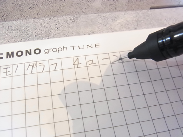 モノグラフチューンでノートに文字を書いている手元のクローズアップ画像